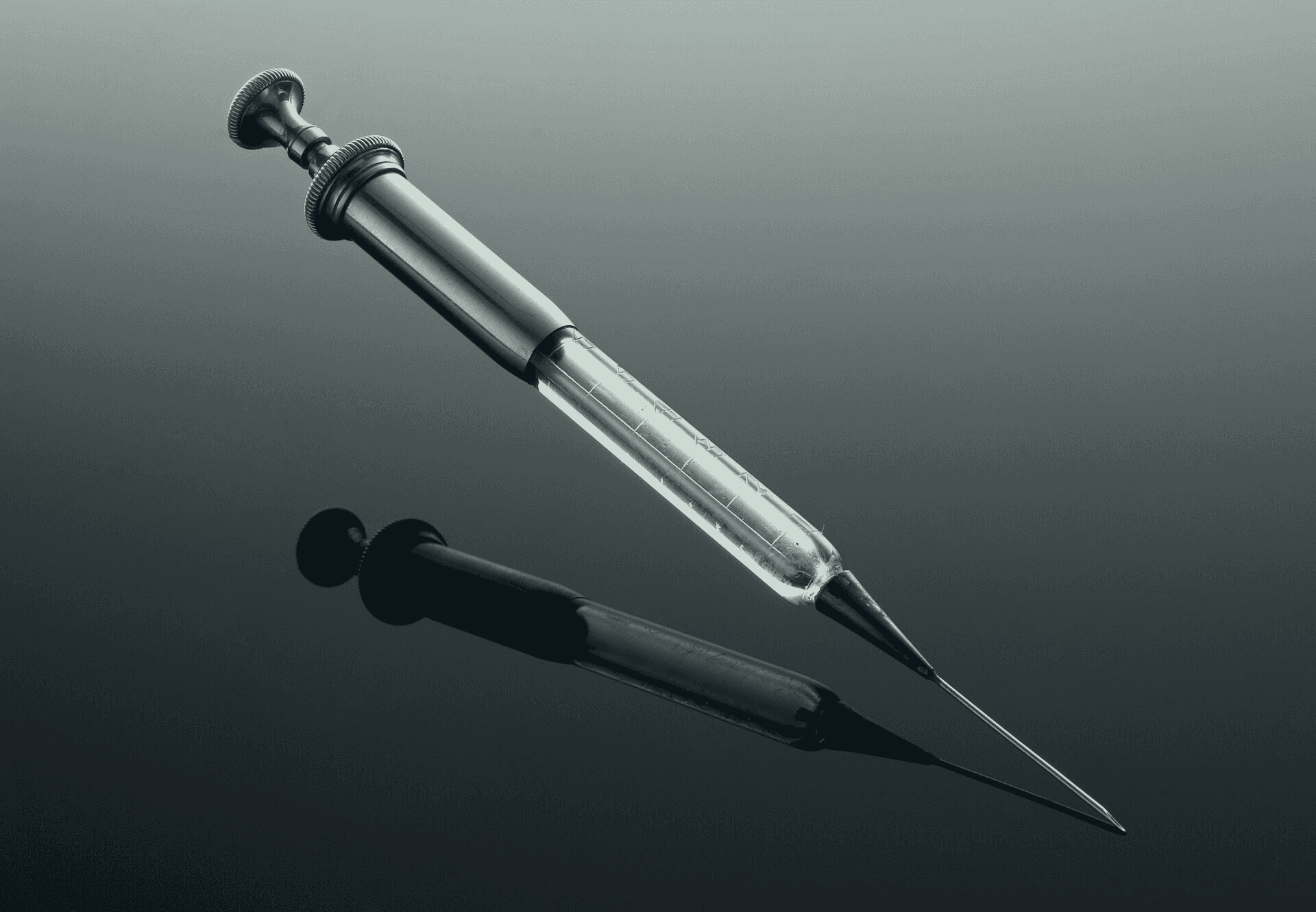 Photograph of a glass and metal hypodermic syringe from the 1850s with its needle attached